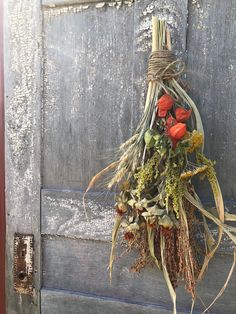 a bunch of dried flowers hanging from a door