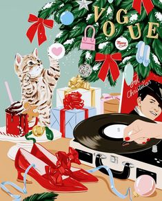 there is a man that is playing the record next to a christmas tree and cat