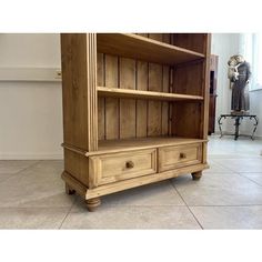 an old wooden bookcase with drawers on the front and bottom, in a living room