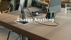 a man sitting in front of a laptop computer on top of a wooden table with the words charge anything