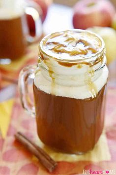 an apple cider in a mason jar with whipped cream and caramel on top