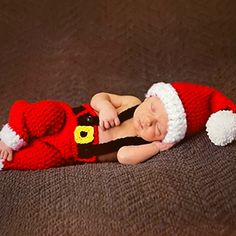 a baby is wearing a santa suit and sleeping