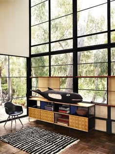 a living room filled with furniture and large windows