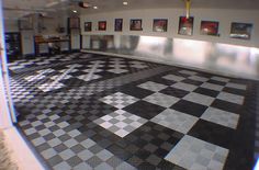 an empty room with black and white checkered flooring on the walls, and pictures hanging on the wall