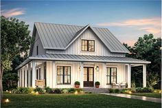 a white house with a metal roof and two windows on the front, surrounded by greenery