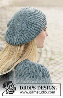 a woman with long blonde hair wearing a blue knitted hat and looking off into the distance