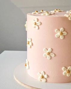 a pink cake with white and gold flowers on it