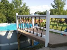 an above ground swimming pool next to a white fence