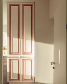 an open door in a room with white walls and red trim on the glass doors