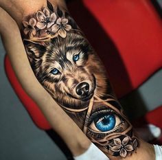 a tattoo with an image of a wolf on it's arm and blue eyes