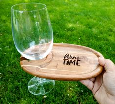 a person holding up a wine glass with the word wine time written on it