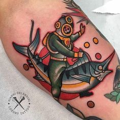 a man with a diving suit on his head riding a fish in the ocean tattoo