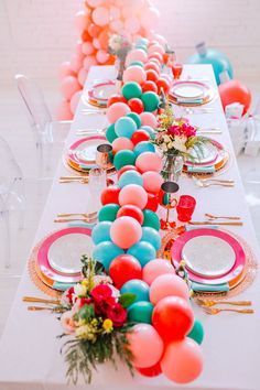 a long table with balloons and plates on it