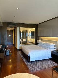 a hotel room with a large bed and wooden floors