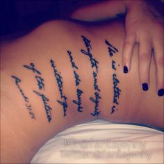 the back of a woman's stomach with writing on her lower body and handwritten words in cursive font