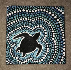 a painting of a sea turtle in blue and white circles on a black background with dots