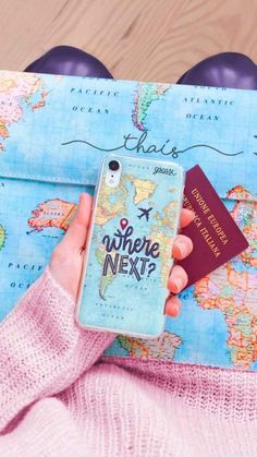 a person holding a passport and cell phone in front of a map with the words where next?