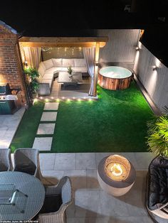 an outdoor living area is lit up at night with lights on the patio and fire pit