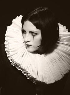 black and white photograph of a woman with dark hair wearing a frilled collar