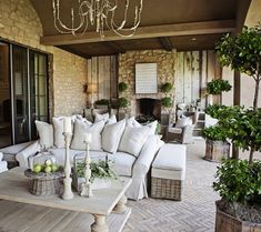 a living room filled with white furniture and lots of greenery on top of it