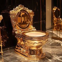 a gold toilet sitting on top of a marble floor next to a golden wall mounted mirror