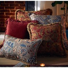 the pillows are all lined up on the floor in front of the window with candles