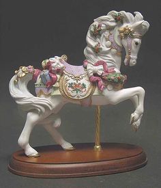 a figurine of a white horse with pink flowers on it's mane