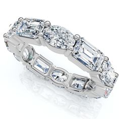 a white gold ring with assorted stones on the sides and an oval cut diamond in the middle