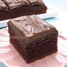 two pieces of chocolate cake sitting on top of a pink plate next to each other