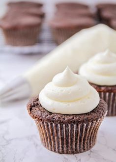 chocolate cupcakes with white frosting on top