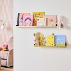 two bookshelves with children's books on them against a wall in a child's room