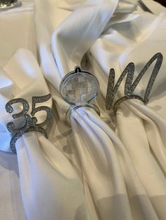 the table cloth is white with silver numbers on it and a cake topper in the middle