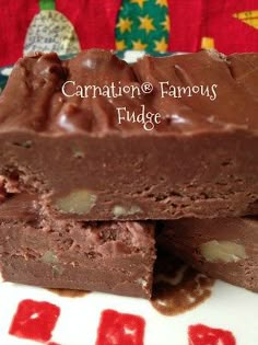 two pieces of chocolate fudge cake sitting on top of a white and red plate