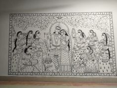 an intricately decorated wall hanging in a room with white walls and black and white artwork