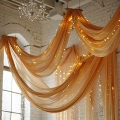 a room that has some lights hanging from the ceiling and drapes on the wall