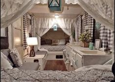 the inside of a camper with curtains over it's bed and kitchen area