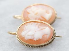 These Mid-century cameo drop earrings are simply lovely!  The carving is exquisite, the colors of the natural shell are perfect, and the mountings are perfectly polished, with a versatile twisting accent. Metal: 14K Yellow Gold Gem: 2 Shell Cameo Gem Measurements: 10.3 x 14.4 mm, Oval Measurements: 12 x 20 SKU #: A36700 Each piece has been identified and graded by a Graduate Gemologist who has been certified by the Gemological Institute of America (GIA). We have six brick-and-mortar storefronts in Maine, Massachusetts, and New Hampshire and have been in business for over 25 years! Please visit our Shop's About Page or our website for more information about our jewelry. For questions about diamond grading, we recommend the Gemological Institute of America (GIA) who were the founders of the Elegant Carved Round Earrings, Elegant Round Carved Earrings, Heirloom Style Earrings For Formal Occasions, Elegant Cameo Earrings, Cameo Round Earrings As Gift, Classic Intaglio Earrings As A Gift, Cameo Drop Earrings For Wedding, Elegant Cameo Earrings As Gift, Elegant Cameo Earrings For Gift