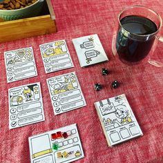 some cards and dices on a table next to a cup of coffee with cereal in it