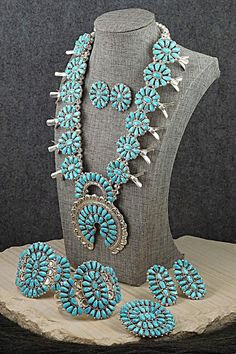 This stunning set featuring Sleeping Beauty turquoise and a sterling silver squash blossom necklace, earrings, pin/pendant, two bracelets, and two rings was made by Navajo silversmith Justina Wilson. The back is signed JW and stamped sterling.Squash BlossomLength: 26"Naja Height: 3 5/8"Naja Width: 3"Blossom Length: 1 5/8"Blossom Width: 1"EarringsLength: 1 1/8"Width: 1"Pin/PendantLength: 2"Width: 2 3/8"BraceletsSize: 5 5/8" (will fit up to 6 7/8" wrist)Gap: 1 1/4"Width: 2 3/8"RingsSizes: 7.25 & 6.5Length: 2"Width: 1 1/8"Free shipping on all orders! We ship with USPS and always include tracking. All orders ship within a day of payment.Returns are accepted up to 30 days after you receive your order. Just send us a message. Our shop offers cash back or store credit. The item must be returned i Silver Squash Blossom Necklace, Turquoise Jewelry Native American, Instagram Jewelry, Two Rings, Squash Blossom Necklace, Squash Blossom, Pin Pendant, Sleeping Beauty Turquoise, Pearl Chain