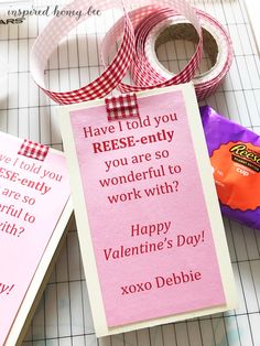 a valentine's day card and some candy on a cutting board with ribbon attached to it