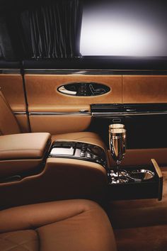 the interior of a luxury car with a wine glass and bottle in front of it