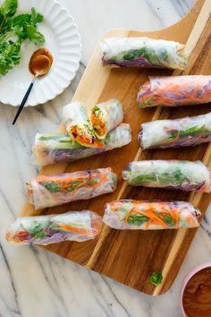 vegetable spring rolls on a cutting board with dipping sauce