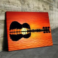 a painting of a guitar on the water at sunset