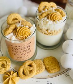 two desserts with cookies and marshmallows are on a table next to eggs