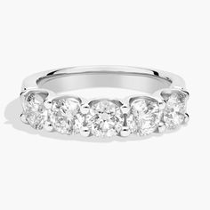 a white gold ring with five stones on the side and four rows of diamonds in each band