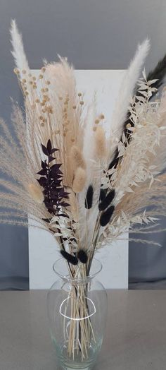 a vase filled with dried flowers on top of a table