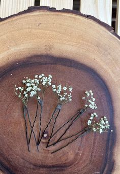 small white flowers are placed in the center of a tree stump