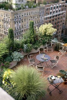 an outdoor patio with tables, chairs and plants