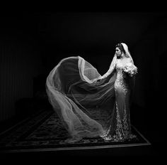 black and white photo of woman in wedding dress with veil