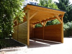 a wooden carport in the middle of a driveway